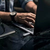 Person typing on a laptop with a SanDisk Ultra Luxe USB Type-C Flash Drive - 256 GB and notebook nearby on a dark surface