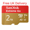 A SanDisk Extreme Go 2TB microSD card shown on a white background with red text at the top reading 'Free UK Delivery'. The card is red on the upper half and metallic gold on the lower half, with white SanDisk branding and technical markings including microSDXC, V30, A2, and U3.